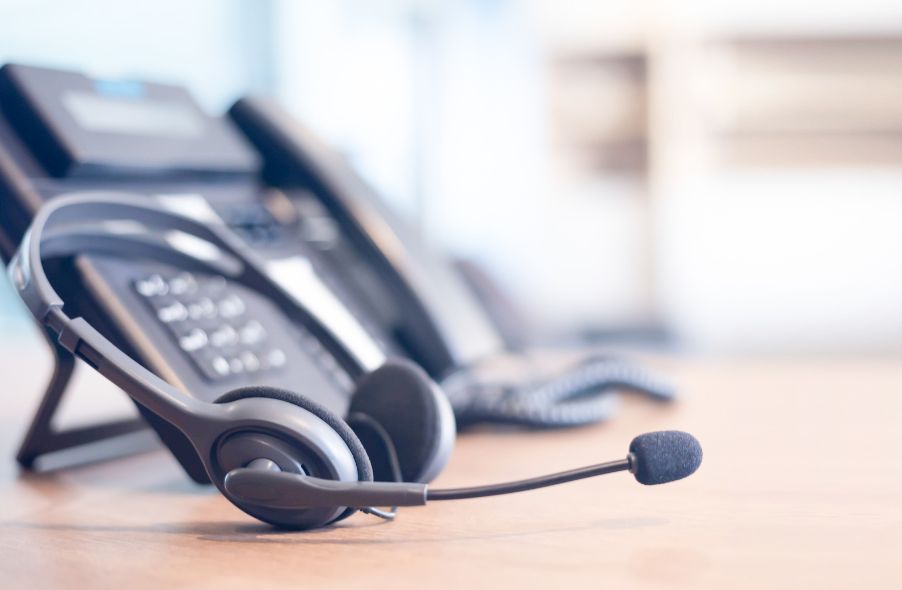 headset and telephone on wooden table